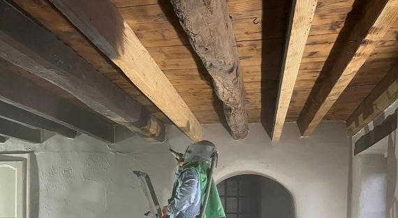 un plafond en bois est en cours de sablage- presentation de la différence entre poutre sabler et non sabler